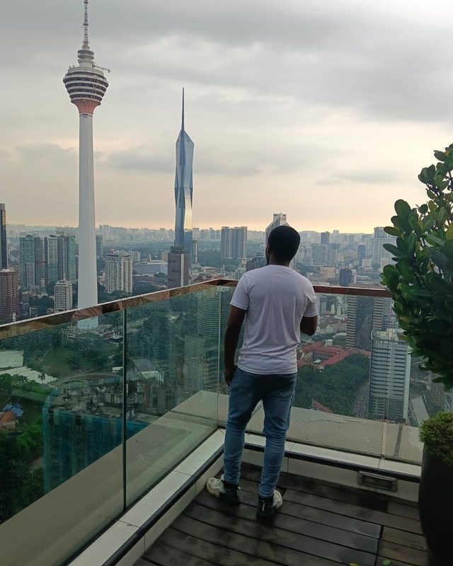 Bah on a rooftop terrace looking out over a city skyline